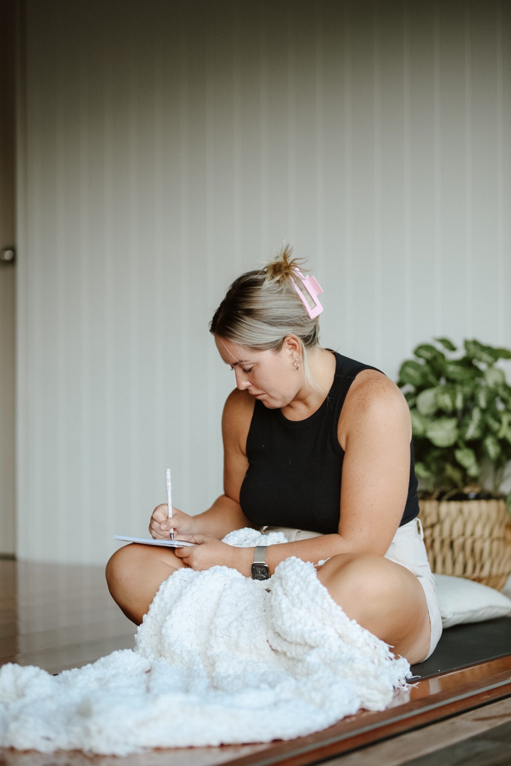 shadow alchemy coaching student sitting on the floor writing in their journal